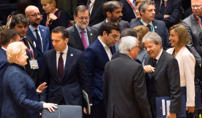 Italy's Prime minister Paolo Gentiloni (2nd R) speaks with European Commission President Jean-Claude Juncker (3rd R) among EU leaders during a special EU leaders' meeting at the Europa building, the main headquarters of European Council and the Council of the EU, in Brussels, on April 29, 2017. The 27 ?EU leaders hold a summit to adopt Brexit negotiating guidelines. EU President Donald Tusk urged the bloc to keep a united front at a special Brexit summit in Brussels, saying it will also help Britain if they can reach a deal. / AFP PHOTO / POOL / Virginia Mayo
