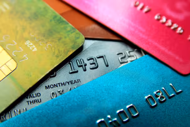 Stack of multicolored credit cards close-up view with selective focus.