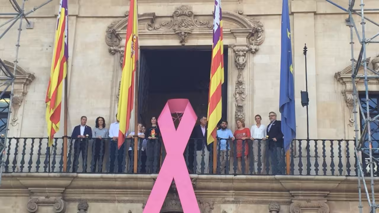 el ajuntament de palma cuelga un lazo rosa contra el cáncer en su fachada