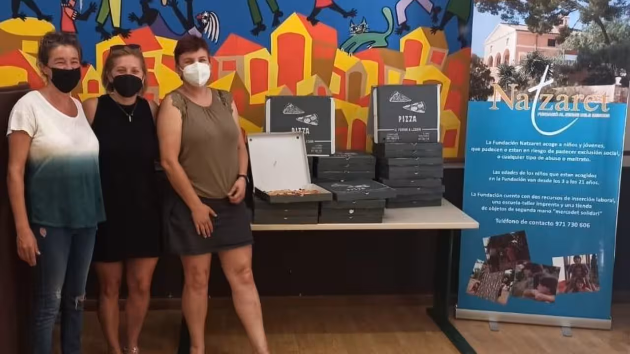 Antònia Massip y Catarina Verger de Fundació Natzaret, recibieron las pizzas de Il Forno de mano de Vicky Barquero.