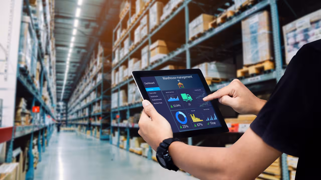 Worker hands holding tablet on blurred warehouse as background