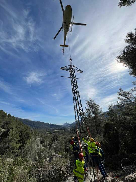 Tècnics instal·lant una torre amb helicòpter